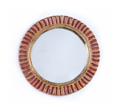 une image représentant un miroir rond orné de rayures rouges et dorées