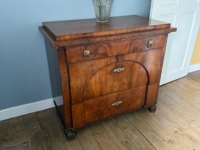 une commode en bois sur laquelle est posé un vase