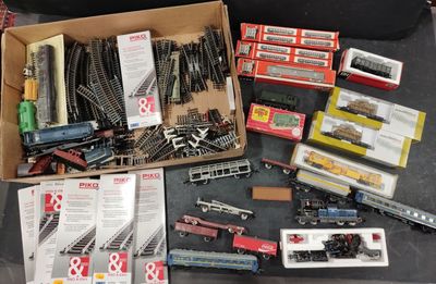 une boîte remplie de rails de train miniature et d'autres trains miniatures