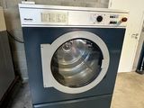 a close up of a washer sitting in a room next to a refrigerator