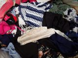 a pile of clothes that is sitting on a bed