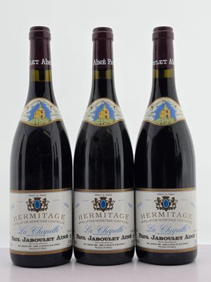 trois bouteilles de vin posées sur une table l'une à côté de l'autre