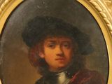 portrait d'un jeune homme portant un chapeau noir et une cape rouge