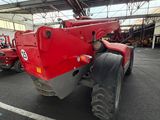a red tractor parked inside of a warehouse next to pallets