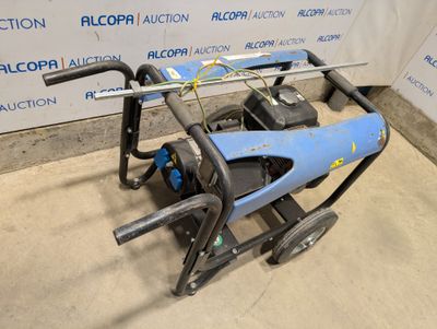 un gros plan d'une machine bleue et noire posée sur un sol en béton