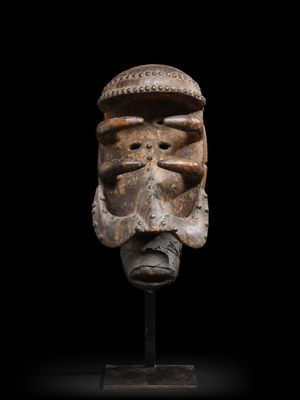 un masque en bois sur fond noir et un fond noir