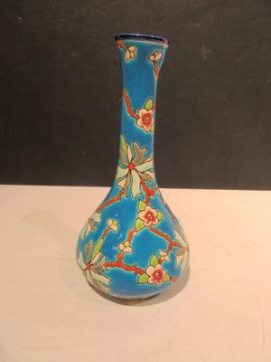 un vase bleu avec des fleurs posé sur une table