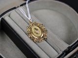 une petite horloge en or dans un écrin, avec un cordon blanc