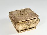 a gold box that is sitting on a white surface