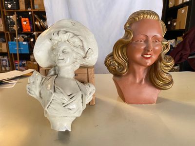 une statue représentant une femme assise à côté d'un buste de femme