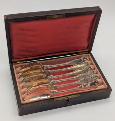 un ensemble de six cuillères de service en métal argenté, présenté dans un coffret en bois