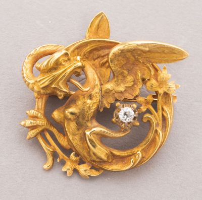an image of a gold brooch with a bird and flowers