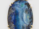 a gold and blue stone pendant with a diamond