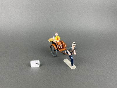 a miniature figurine of a man in a horse drawn carriage