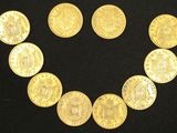 several gold coins arranged in a circle on a black surface