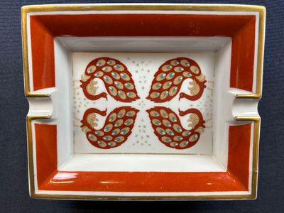 a red and white plate with two birds on it