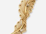 un gros plan sur une broche en feuille d'or sertie d'un diamant