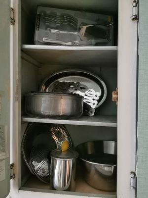 un placard contenant des casseroles et des poêles