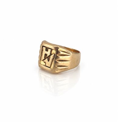 un gros plan d'une bague en or sur laquelle figure la lettre « w »
