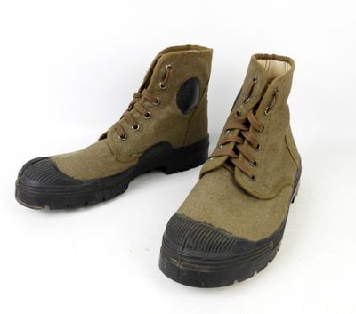 une paire de bottes marron à semelles noires sur fond blanc