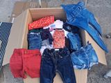 a cardboard box full of clothes sitting on the ground