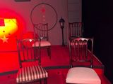 four chairs in a room with a red light in the background