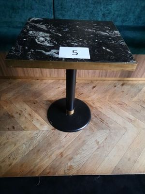 une petite table sur laquelle figure un chiffre, posée sur un plancher en bois
