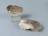 deux morceaux de quartz posés sur un socle en verre transparent, sur une table