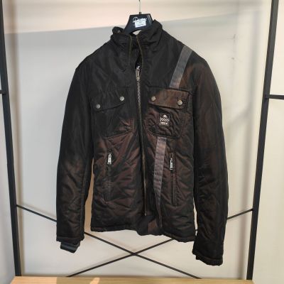 La veste est suspendue à un portant dans un magasin de vêtements.