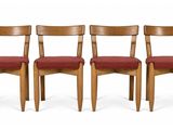 three wooden chairs with red upholstered seats on a white background