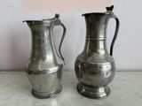 deux vases en argent posés l'un à côté de l'autre sur une table