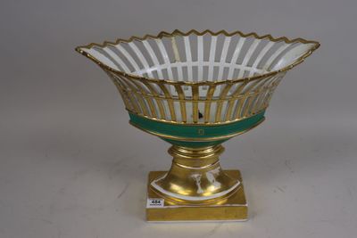 une image représentant un bol en verre doré et vert posé sur un socle
