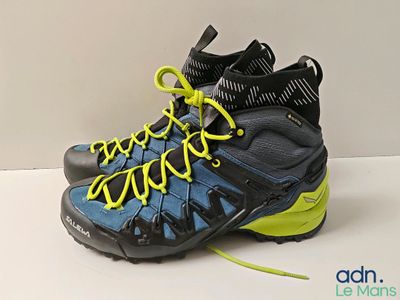 un gros plan sur une paire de chaussures de randonnée avec des lacets jaunes