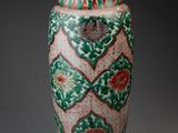 a green and red vase sitting on a table