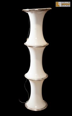 un grand vase blanc posé sur un fond noir