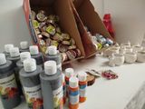 many bottles of paint sitting on a counter next to a box of candy
