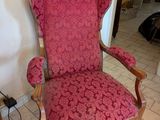 une chaise rouge qui se trouve dans le coin d'une pièce