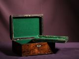 a small wooden box with a green lid on a purple background