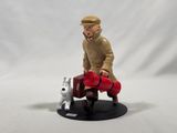 a figurine of a man sitting on a bench with a dog
