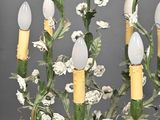 a chandelier with flowers and candles on it