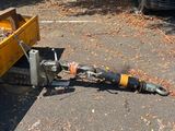 a yellow trailer with a tool attached to it in the parking lot