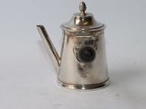 a silver tea pot with a handle on a white table