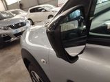 cars are parked in a garage with a mirror on the side of the car