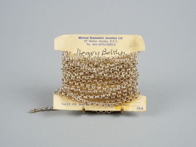 une image représentant une bobine de perles argentées suspendue à une chaîne