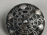 a close up of a metal button on a white surface