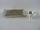 a silver plate with a mirror on it and a silver bowl on the table