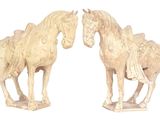 deux statues de chevaux placées côte à côte sur une surface blanche