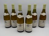 six bouteilles de vin sont alignées sur une surface blanche