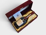 une bouteille d'alcool dans un coffret en bois orné d'un ruban doré