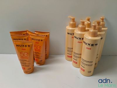 four bottles of sunscreen lotion sitting on a table next to a tube of sunscreen lotion